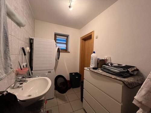 Funktionaler Hauswirtschaftsraum mit Waschmaschine und Stauraum - 