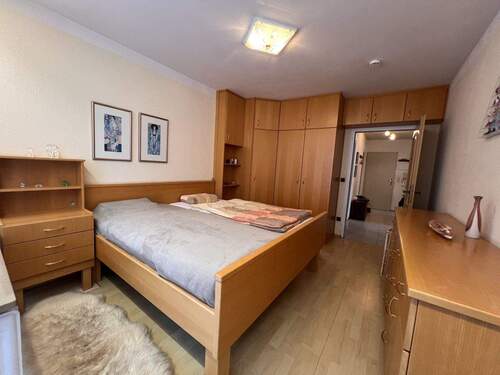 Geräumiges Schlafzimmer mit maßgeschneiderten Einbauschränken und durchdachter Raumaufteilung - 