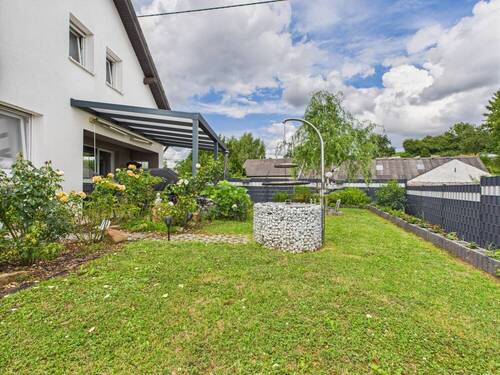 Seitenansicht rechts - Einfamilienhaus mit kleinem Außenpool in ruhigerer Lage.