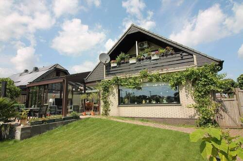 Rückseite mit Seitenblick auf die Terrasse - Bungalow mit großem Wintergarten und Einliegerwohnung im Dachgeschoss, Rheinberg-Ossenberg, mit großem Garten