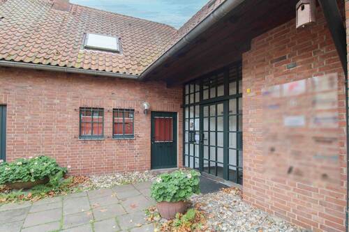 Stilvoller Eingangsbereich mit traditioneller Klinkerarchitektur und begrüntem Vorplatz - 
