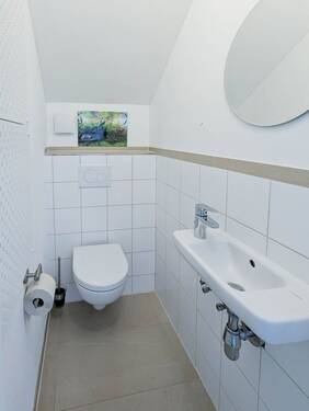 mit hell gefliestem Gäste-WC. - 