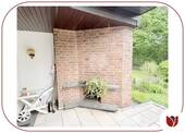 Terrasse vor dem Essbereich mit Außenkamin und Gartenblick - 