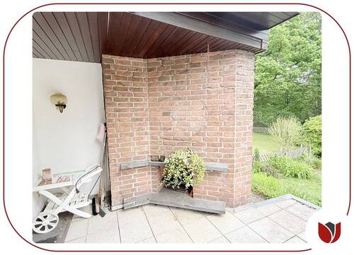 Terrasse vor dem Essbereich mit Außenkamin und Gartenblick - 