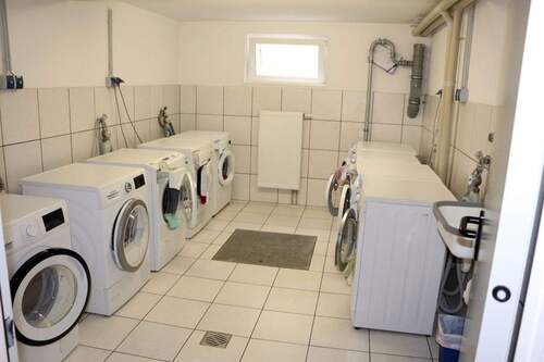 Komfortable Waschküche mit modernen Geräten und praktischer Infrastruktur - 