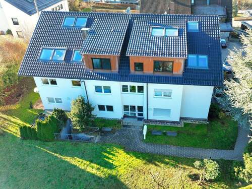 2. Hausansicht Ostseite DJI - Hier erwartet Sie eine schöne, helle 2 12 Zimmerwohnung mit gr. Terrasse und Grünfläche.