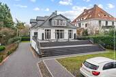 Garten, Parkbereich und Treppen zur Südterrasse und zum Hauseingang (links). - 9 Zimmer Einfamilienhaus zum Kaufen in Bremen