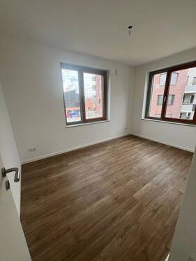 Helles Zimmer mit Holzfußboden - ERSTBEZUG! LETZES HAUS! Größere 4-Zimmer-Wohnung mit 2 Bädern und West-Loggia