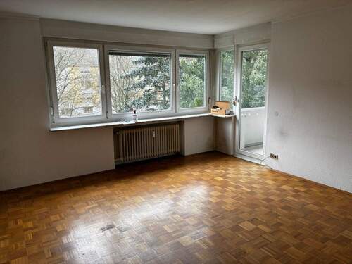  Wohnzimmer mit Fenster und Zugang zum Balkon, Parkettboden - 