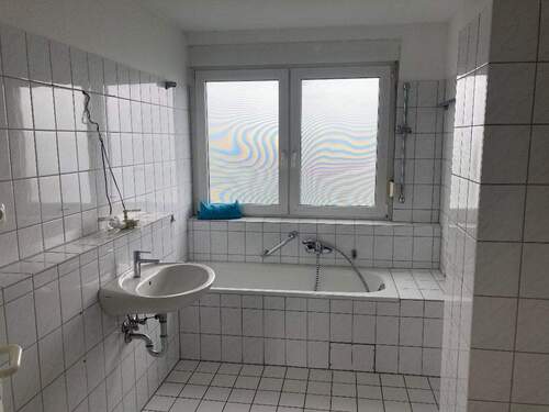 TGL-Bad mit weißen Fliesen und weißen Sanitärobjekten - 