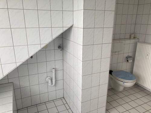 TGL-Bad mit weißen Fliesen und weißen Sanitärobjekten - 