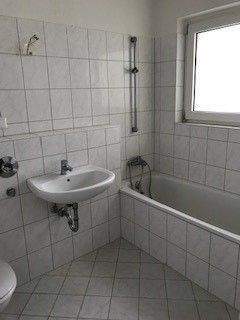 BEISPIELBILD: Tageslichtbad mit weißen Fliesen und weißen Sanitärobjekten - Etagenwohnung mit 55,50 m&sup2; in Bad Vilbel zur Miete