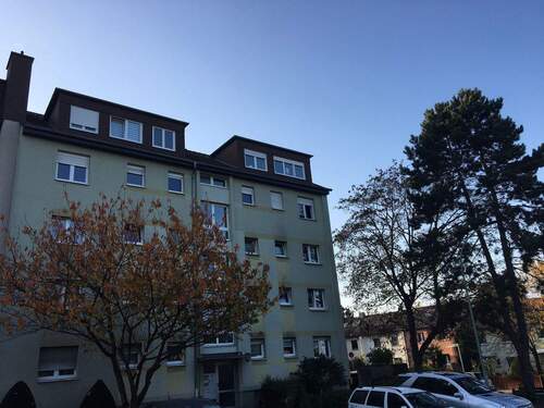 Gebäude Vorderseite des mehrstöckigen Wohnhauses umgeben von Grünanlagen mit Bäumen und Sträuchern - 