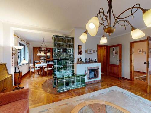 Wohnzimmer mit Kachelofen im Erdgeschoss - 7 Zimmer Einfamilienhaus zum Kaufen in Ostseeheilbad Zingst