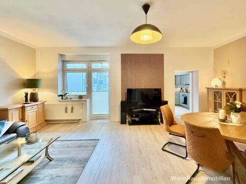 Das Wohnzimmer mit angrenzender Küche und Balkon - 