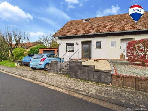 RE/MAX Immobilien DeLux Einfamilienhaus Niederlosheim Seitenansicht - 4 Zimmer Doppelhaushälfte zum Kaufen in Losheim am See / Niederlosheim