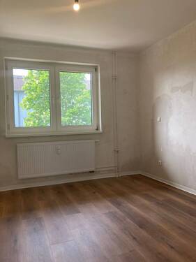 Schlafzimmer mit neuem Fußbodenbelag in Holzoptik, Wände sind tapezierfertig vorbereitet - 