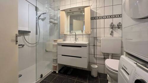 Gepflegtes Badezimmer mit Dusche und Waschmaschinenanschluss - 