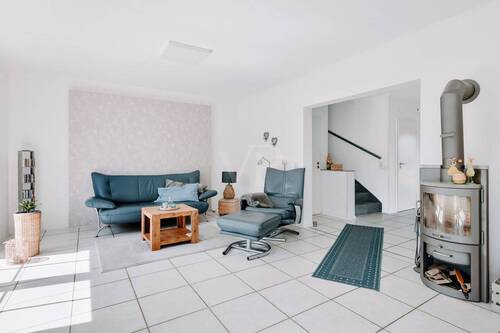 Im Erdgeschoss: Wohnbereich mit stilvollem Schwedenofen und direktem Terrassenzugang - 