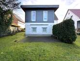 Gartenansicht - Nicht vermietetes Einfamilienhaus mit Einliegerwohnung und Garagen in Top Wohnlage