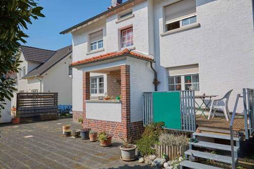 Gepflasterter Außenbereich mit überdachtem Eingangsportal und direktem Terrassenzugang - 6 Zimmer Einfamilienhaus in Rodgau