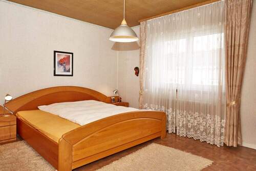 Helles Schlafzimmer mit großflächigen Fenstern und hochwertiger Ausstattung - 