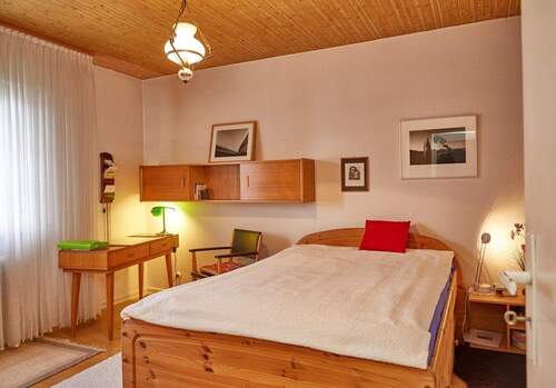 Schlafzimmer mit charaktervollem Holzdeckenbalken und praktischer Raumaufteilung - 