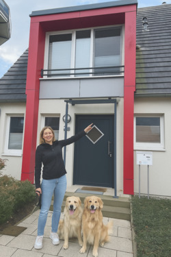 deichhaus foto frau zeigt auf haus mit hunden.png - 4 Zimmer Einfamilienhaus in Breege