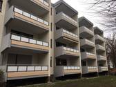 Frontansicht eines mehrstöckigen Gebäudes mit Balkonen, umgeben von Wiesen und Bäumen. - 1 Zimmer Etagenwohnung in Bad Homburg vor der Höhe