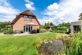 Südansicht mit Gartenteich und Sauna - Attraktives reetgedecktes Friesenhaus * Kaminofen * traumhaftes Grundstück * Gartensauna *
