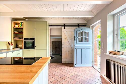 Moderne Küche mit Klöntür zur Frühstücksterrasse - 