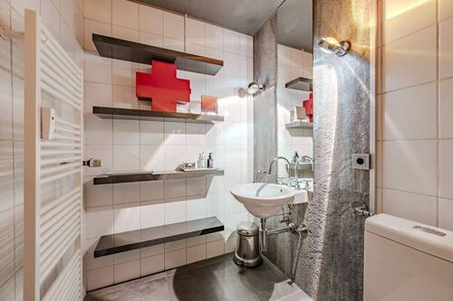 Badezimmer mit WC, Waschbecken und Dusch-Badewanne - 