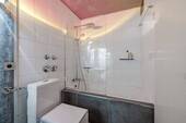 Badezimmer mit WC, Waschbecken und Dusch-Badewanne - 