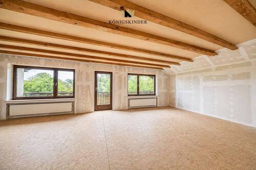 Großzügige Ausbaureserve mit Balkon und sichtbaren Holzbalken - 