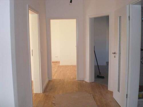 Heller Flur mit neuen Türen und Parkett - 