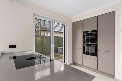 Einbauküche mit grifflosen Türen und Kochinsel mit Induktionsherd inkl. integriertem Dunstabzug. - 3 Zimmer Etagenwohnung in Bremen