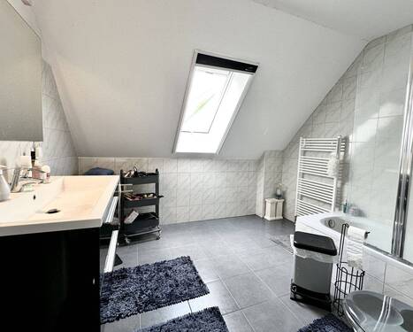 Geräumiges Badezimmer mit Badewanne und Dusche - 