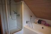 Modernes Badezimmer mit hochwertiger Ausstattung, Badewanne und einer Dusche. - 