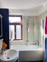 Badezimmer mit Wanne und Fenster - 
