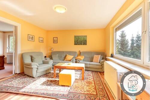 Gemütliches Wohnzimmer mit großem Fenster und Ausblick - 