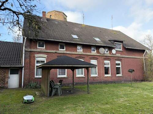 Seitenansicht vom Haus mit Sitzgelegenheit - 9 Zimmer Mehrfamilienhaus, Wohnhaus in Rastede