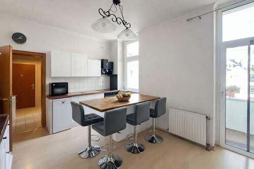 Küchenbereich mit Theke und Zugang zum Balkon - 2 Zimmer Etagenwohnung in Düsseldorf
