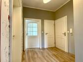 Flur mit Blick zur Wohnungstür/ WC und Zugang Wohnzimmer - 
