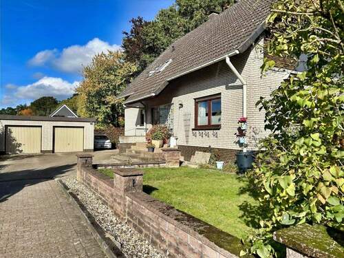 Seitliche Hausansicht mit Hofeinfahrt und Doppelgarage - Mehrfamilienhaus, Wohnhaus mit 169,00 m&sup2; in Walsrode zum Kaufen