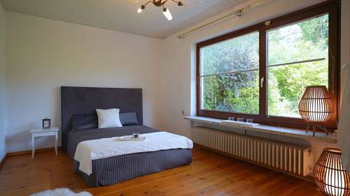 Das Schlafzimmer mit Dielen und Blick in den Garten... - 