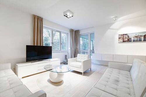 Helles Wohnzimmer mit Zugang zur Loggia - Großzügige Terrassenwohnung. An der Isar im Grünen gelegen.