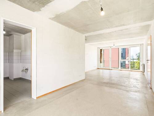 offener Wohnbereich mit Blick zum Balkon - 