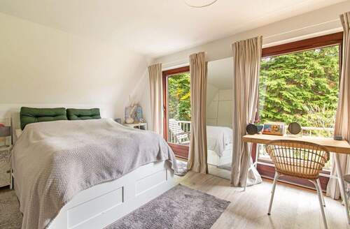 Schlafzimmer im Obergeschoss mit Zugang zum Balkon - 