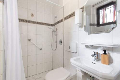 Gefliestes Erdgeschossbad mit Dusche und Tageslichteinfall - 