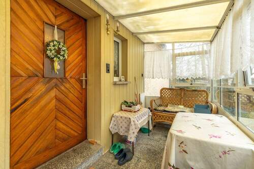 Hauseingangstür über Veranda mit Sitzecke - 